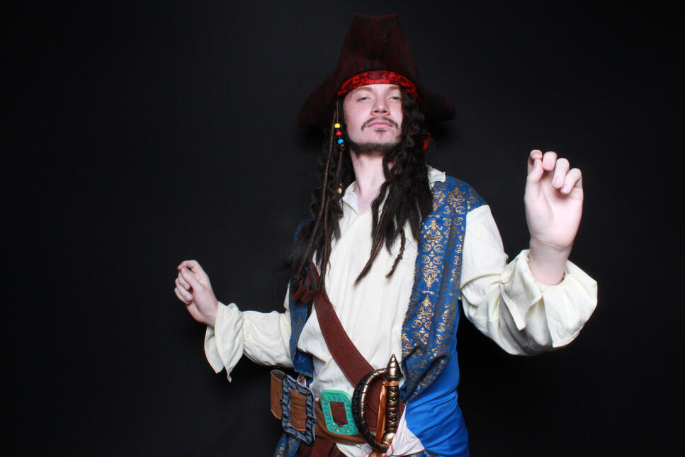 a man posing for a photo booth photo dressed up as captain jack sparrow for halloween